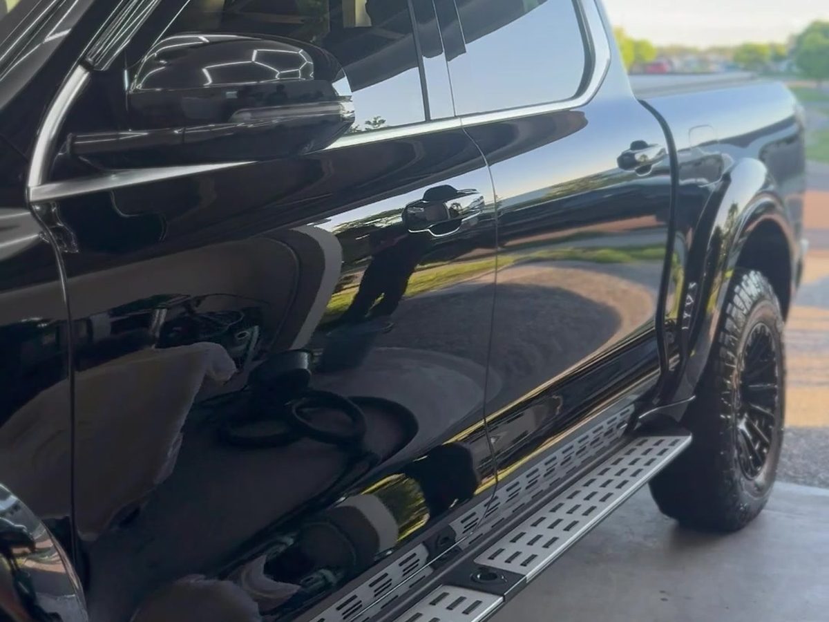 Black ute with a deep gloss finish parked under a carport